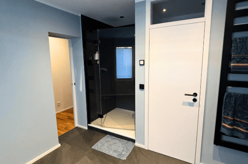 Nachher: modernes Bad Modernes Badezimmer mit Dusche, grauen Wänden und Holzfußboden.